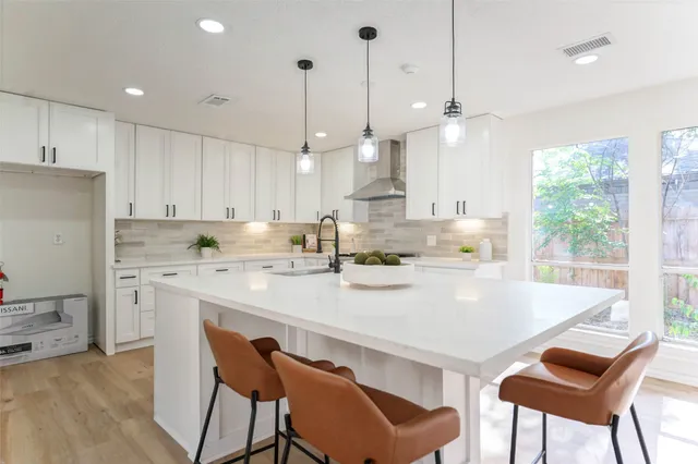 a kitchen with stainless steel appliances a table and chairs in it