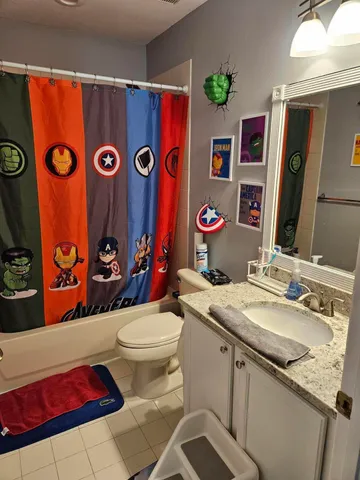 a bathroom with a sink mirror vanity and toilet