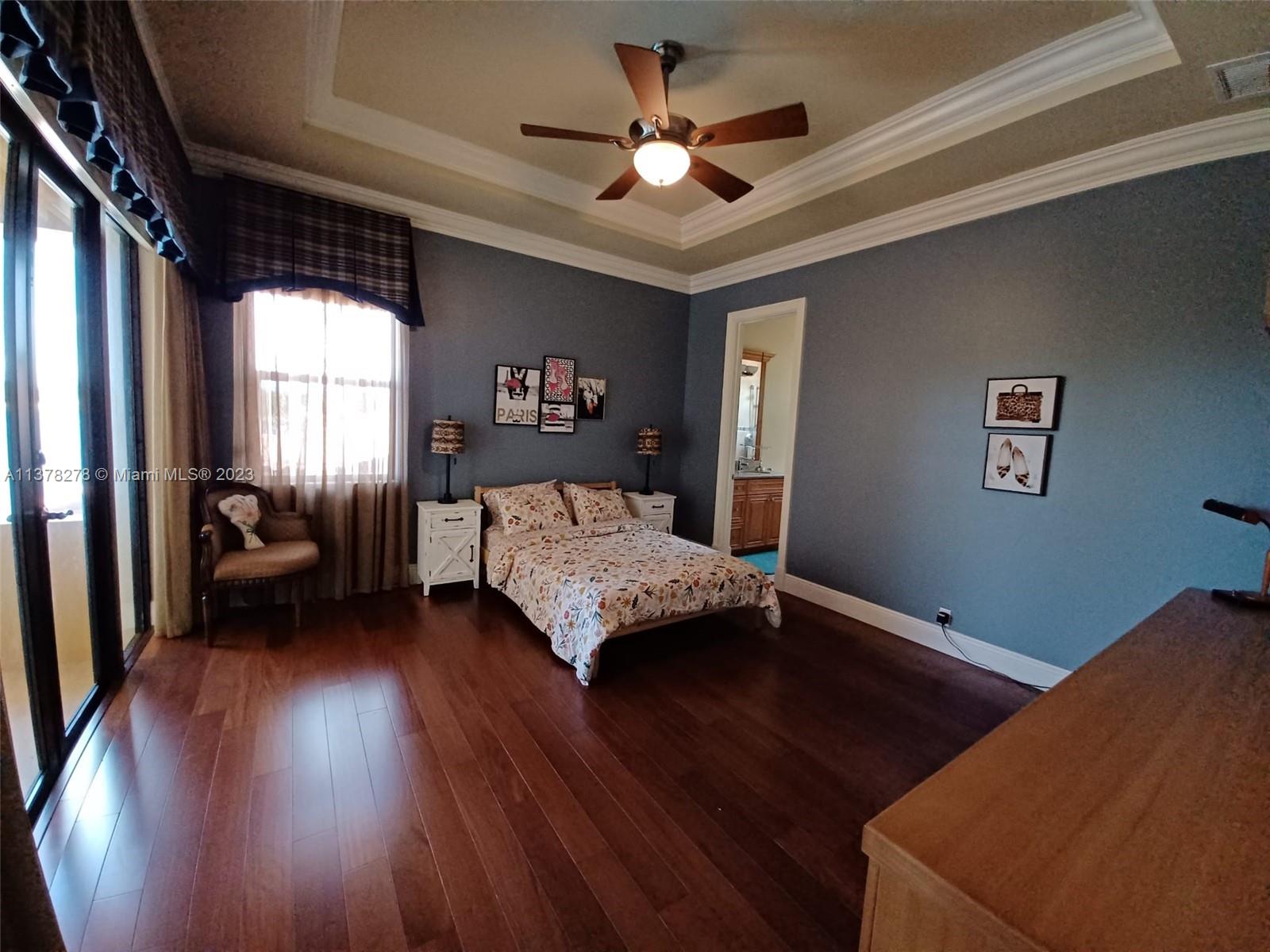 19349 Waters Edge Street Weston, FL 33332 - Photo 31 of 63 a bedroom with a bed and a chandelier