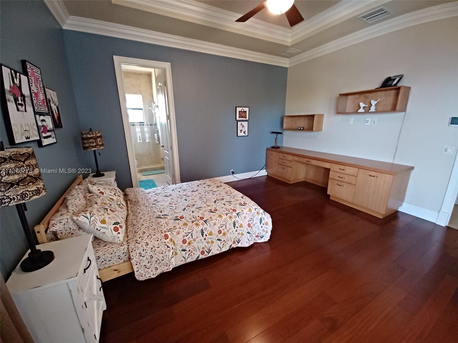 19349 Waters Edge Street Weston, FL 33332 - Photo 32 of 63 a bedroom with a bed and a chandelier