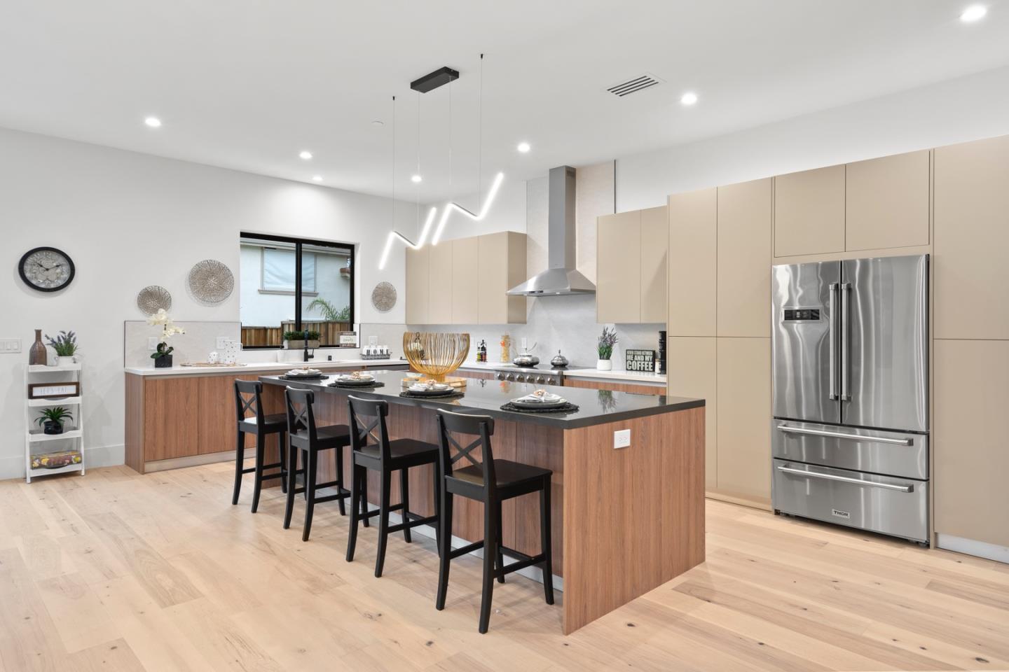 719 East Homestead Road Sunnyvale, CA 94087 - Photo 14 of 47 a kitchen with stainless steel appliances kitchen island granite countertop a refrigerator oven a sink a dining table and chairs with wooden floor