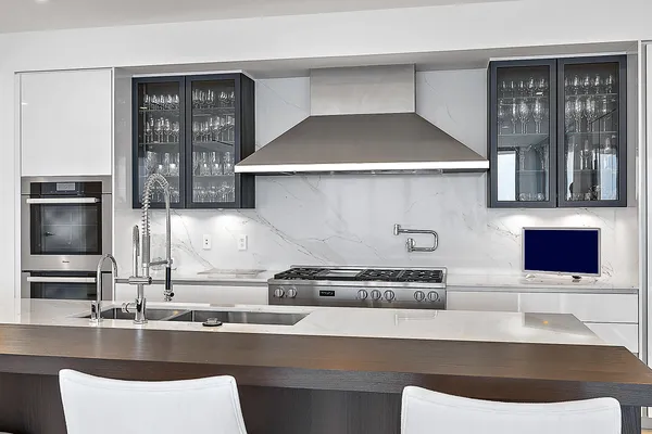 a kitchen with a sink and a stove with wooden floor