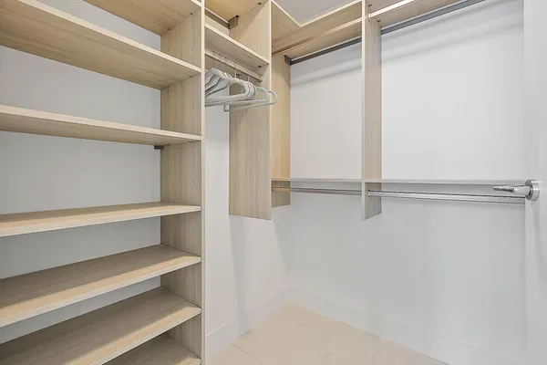 a view of walk in closet with empty racks