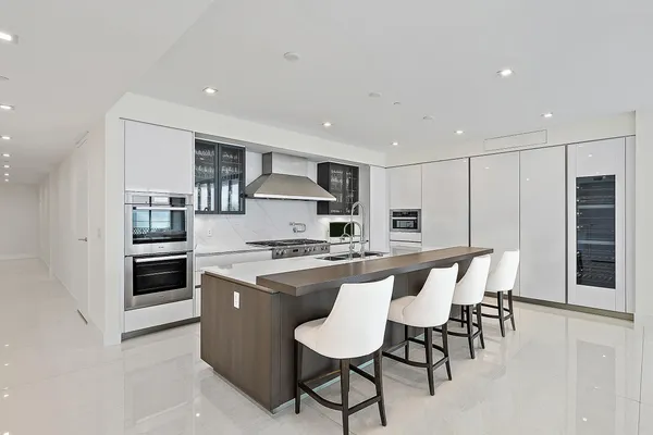 a kitchen with stainless steel appliances a table and chairs in it