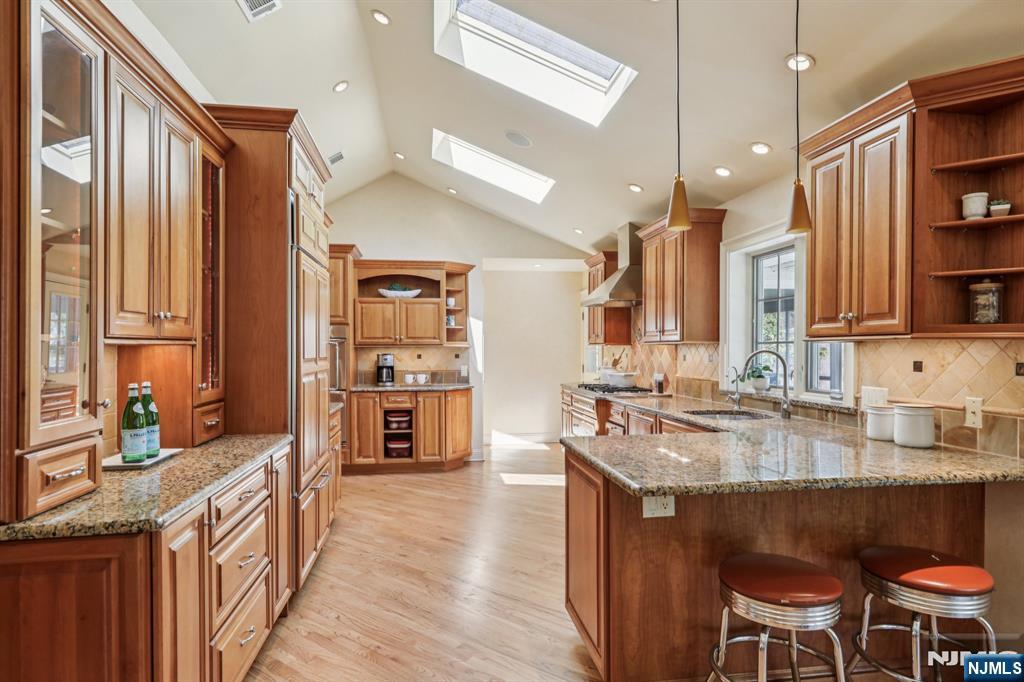 132 Dimmig Road Upper Saddle River, NJ 07458 - Photo 11 of 33 a kitchen with stainless steel appliances granite countertop a table chairs in it and a wooden floors
