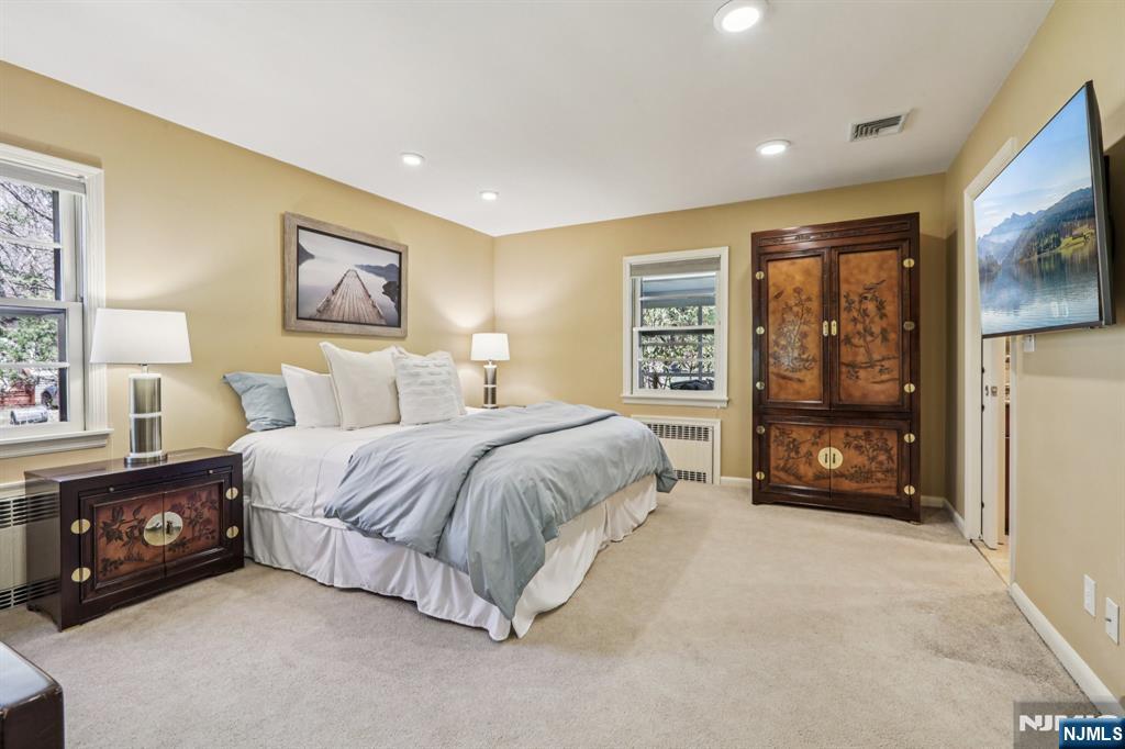 132 Dimmig Road Upper Saddle River, NJ 07458 - Photo 17 of 33 a spacious bedroom with a bed a painting on the wall and a large window