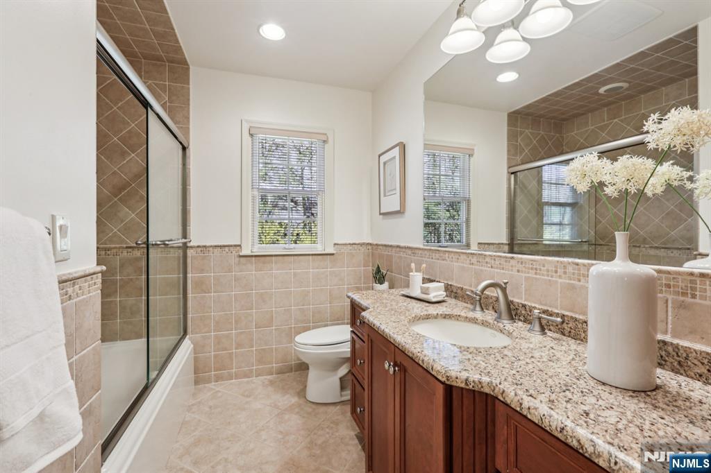 132 Dimmig Road Upper Saddle River, NJ 07458 - Photo 22 of 33 a bathroom with a granite countertop sink a toilet a mirror and shower