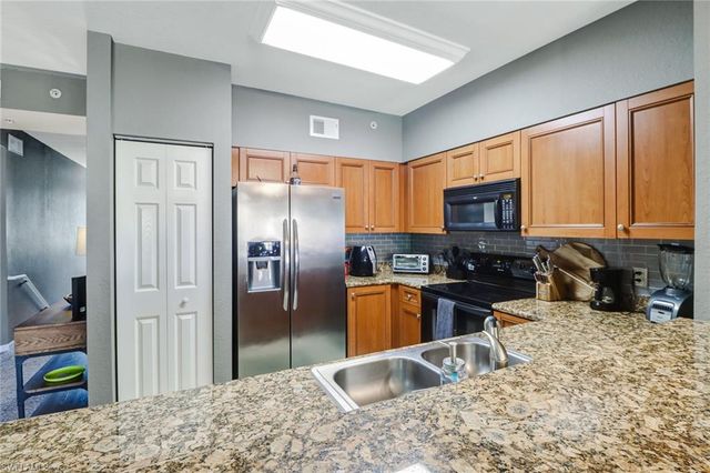 a kitchen with stainless steel appliances granite countertop a refrigerator stove top oven a sink and dishwasher