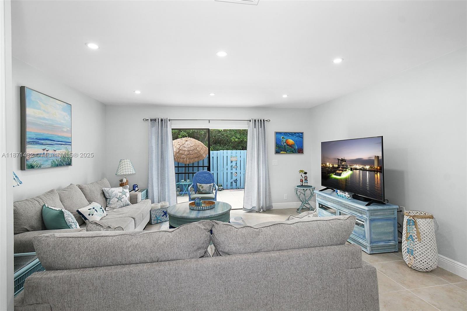 9421 South Ocean Drive, Unit 90 Jensen Beach, FL 34957 - Photo 12 of 49 a living room with furniture and a flat screen tv