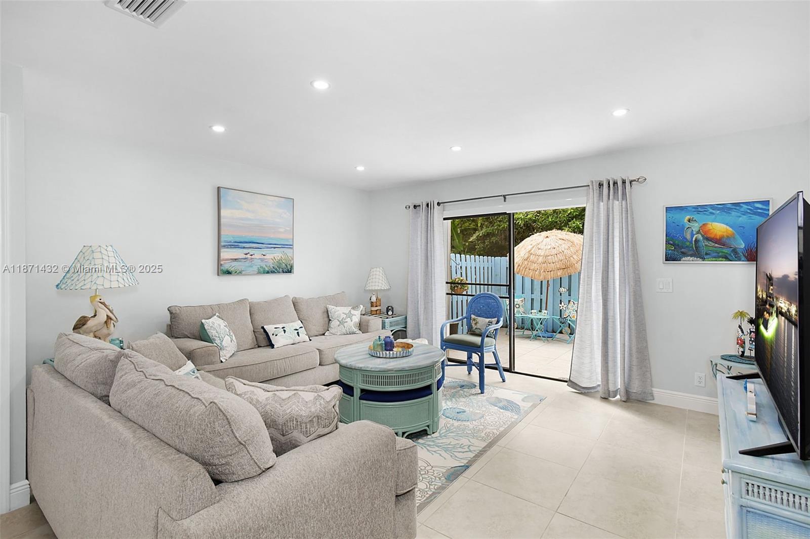 9421 South Ocean Drive, Unit 90 Jensen Beach, FL 34957 - Photo 13 of 49 a living room with furniture and a flat screen tv