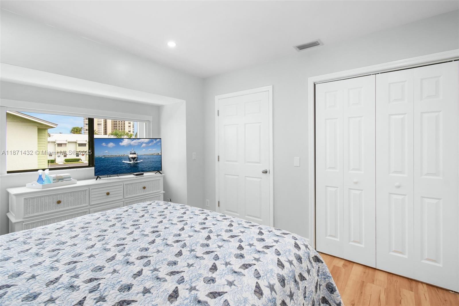 9421 South Ocean Drive, Unit 90 Jensen Beach, FL 34957 - Photo 31 of 49 a bedroom with a bed and a flat screen tv