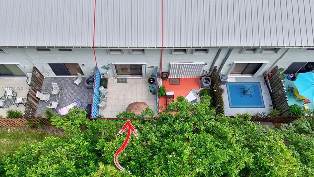 an aerial view of a house with a yard and large trees