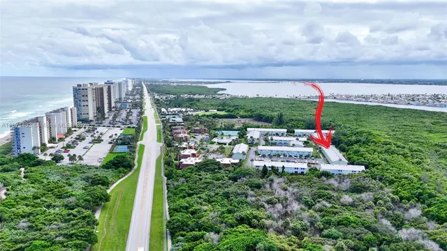 a view of a white house next to a yard