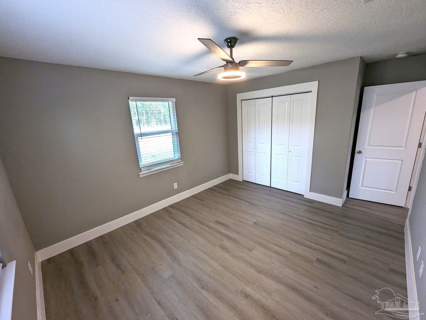 6045 Hamilton Bridge Road Milton, FL 32570 - Photo 26 of 31 a view of an empty room with wooden floor and a window