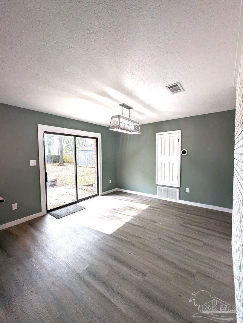 6045 Hamilton Bridge Road Milton, FL 32570 - Photo 7 of 31 a view of an empty room with wooden floor and a window