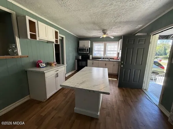 a kitchen with stainless steel appliances granite countertop a refrigerator a stove top oven a sink dishwasher and wooden floor