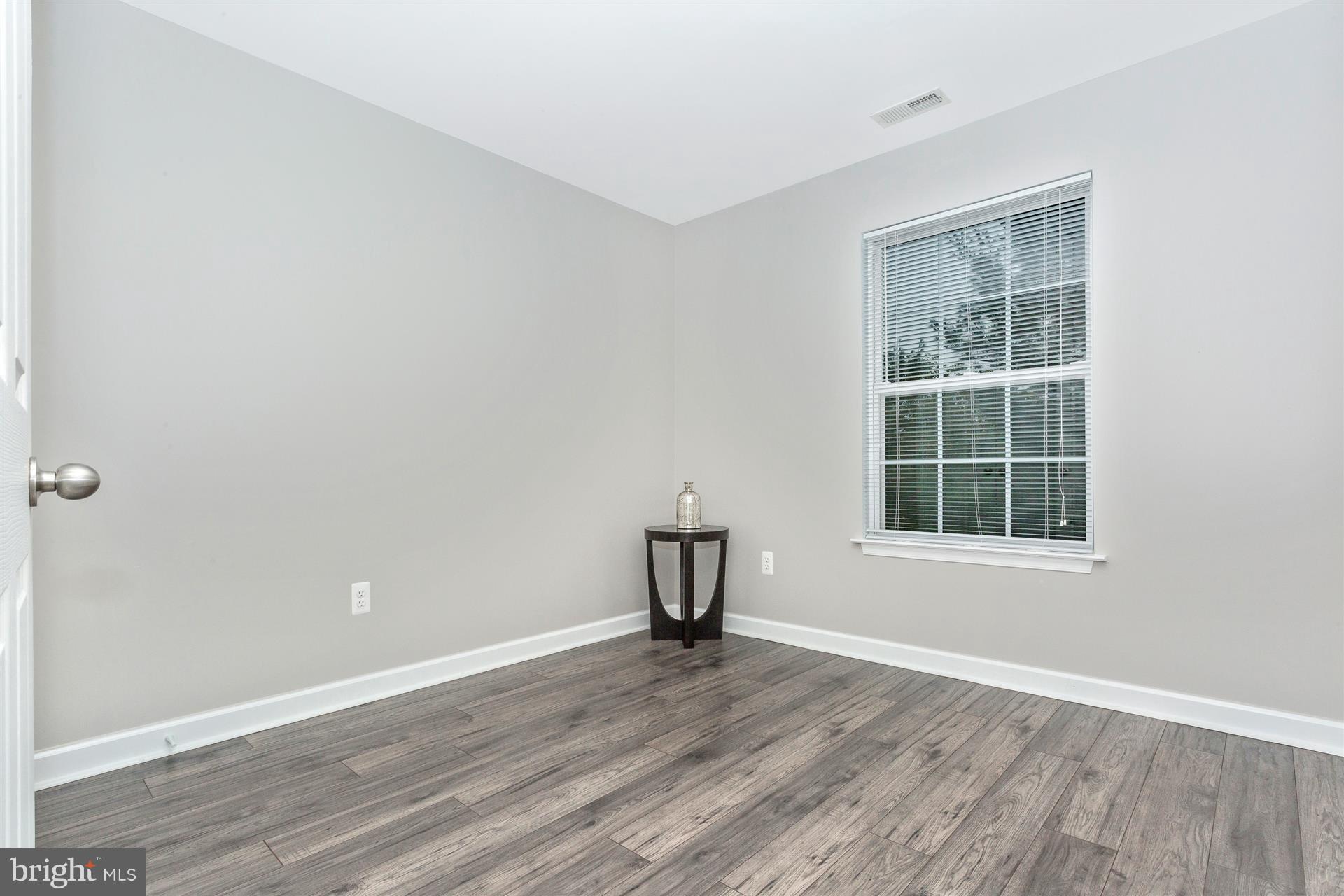 6408 View Point Court Frederick, MD 21703 - Photo 17 of 30 a view of an empty room with wooden floor and a window