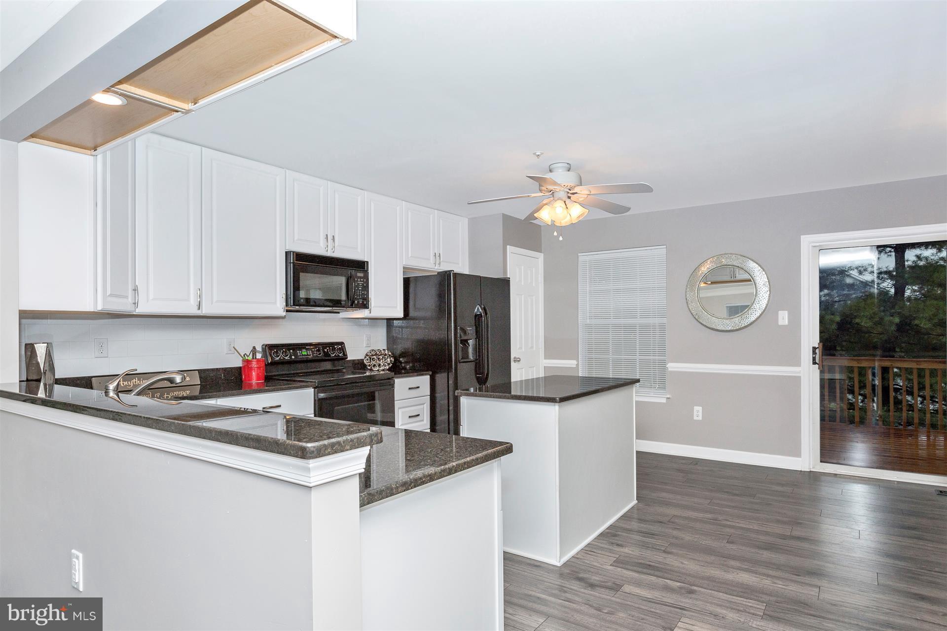 6408 View Point Court Frederick, MD 21703 - Photo 6 of 30 a kitchen with granite countertop a sink a stove top oven and cabinetry