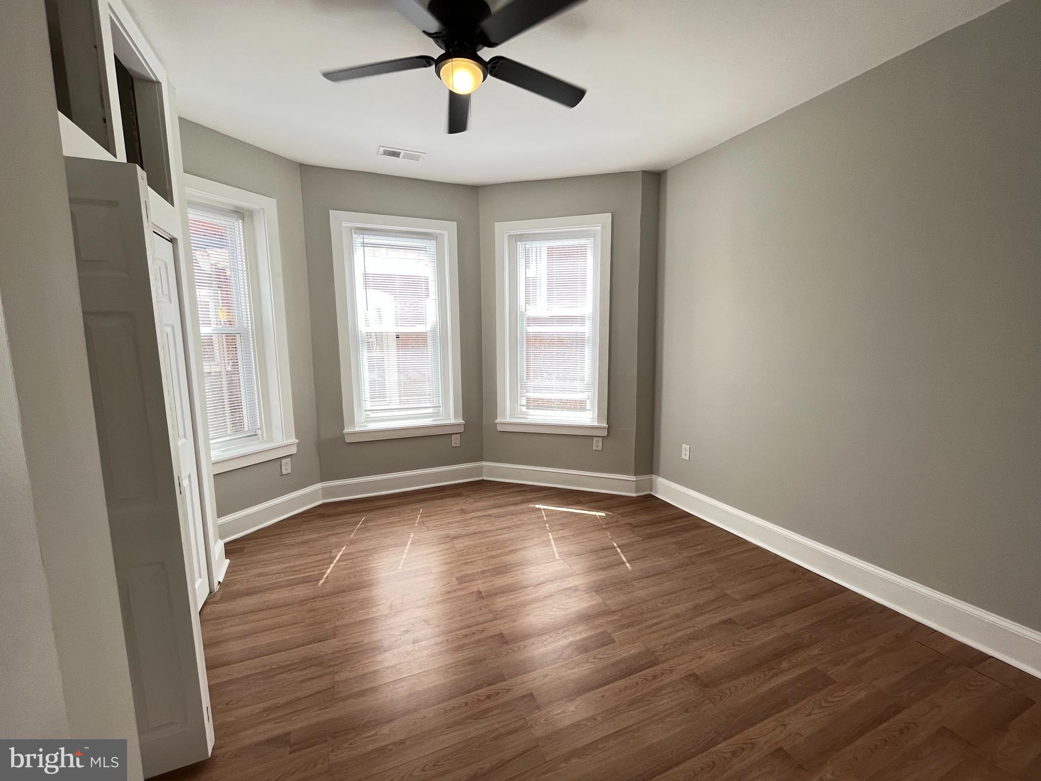 853 Wynnewood Road, Unit 2 Philadelphia, PA 19151 - Photo 4 of 10 a view of an empty room with wooden floor and a window
