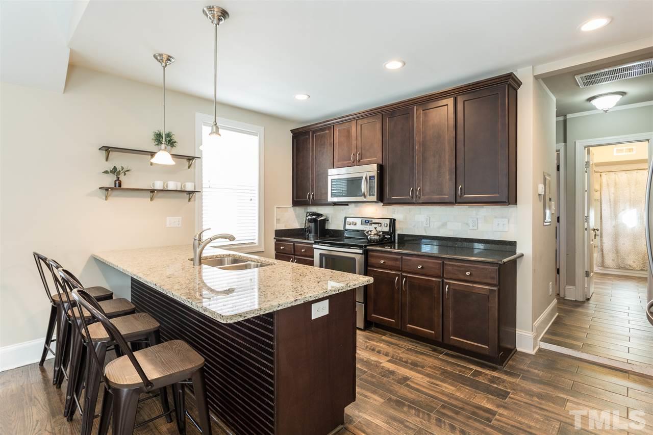 575 East Cabarrus Street Raleigh, NC 27601 - Photo 3 of 20 a kitchen with a stove a sink a microwave and wooden cabinets