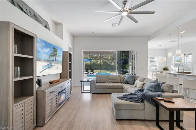 a living room with furniture a flat screen tv and a large window