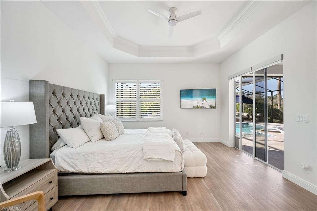 9121 Quartz Lane Naples, FL 34120 - Photo 17 of 36 Bedroom with access to exterior, wood finished floors, ornamental molding, a raised ceiling, and a ceiling fan