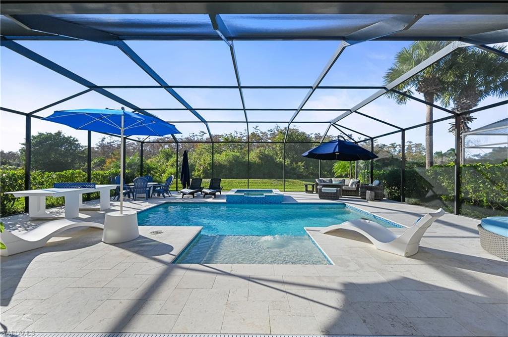9121 Quartz Lane Naples, FL 34120 - Photo 23 of 36 View of pool with a sunroom, a pool with connected hot tub, glass enclosure, a patio, and an outdoor living space