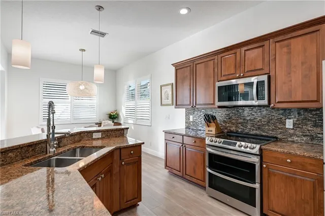 a kitchen with stainless steel appliances a stove sink microwave and cabinets