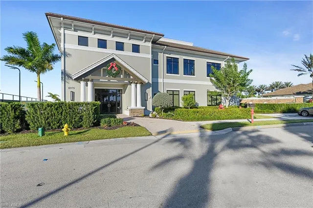 a front view of a house with a yard and potted plants
