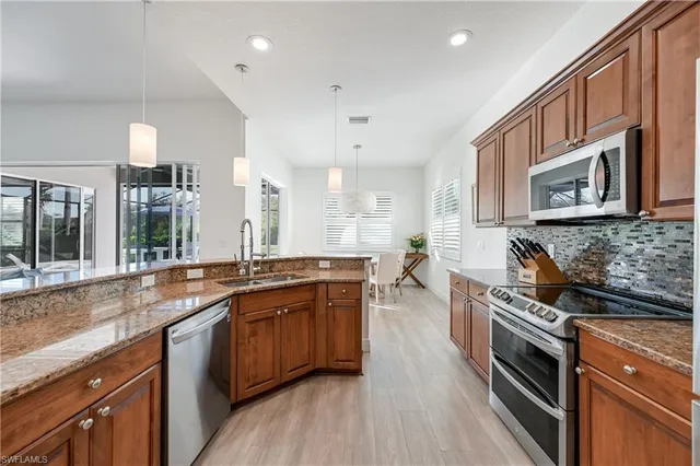 a kitchen with stainless steel appliances granite countertop a stove and a sink