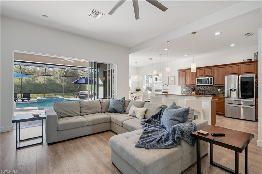 9121 Quartz Lane Naples, FL 34120 - Photo 8 of 36 Living room with a sunroom, light wood-type flooring, ceiling fan, healthy amount of natural light, and recessed lighting