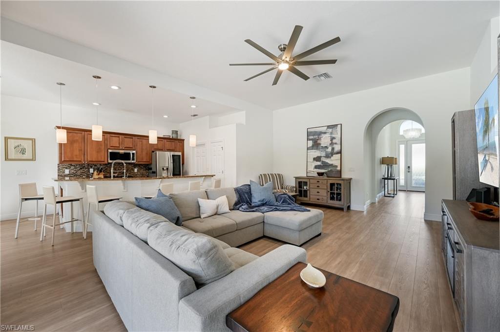 9121 Quartz Lane Naples, FL 34120 - Photo 9 of 36 Living room with arched walkways, light wood-style floors, and ceiling fan