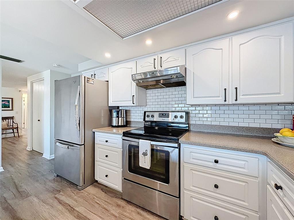 6521 Leeside Isle Hudson, FL 34667 - Photo 13 of 59 a kitchen with stainless steel appliances white cabinets and a stove top oven