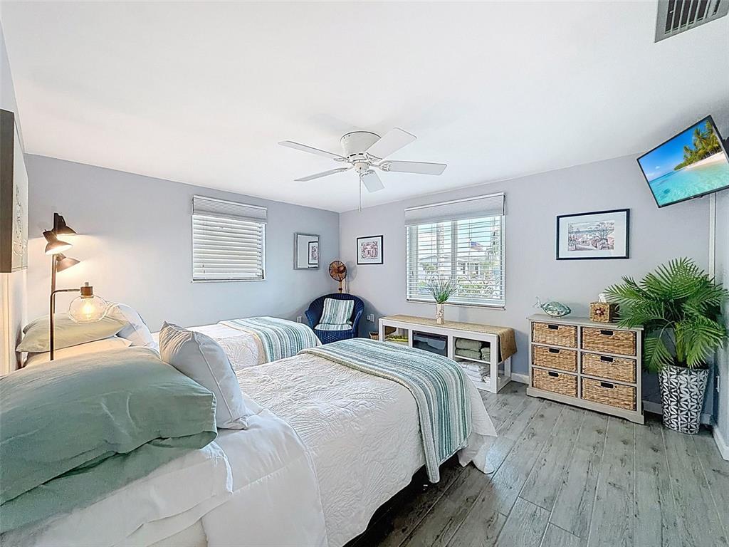 6521 Leeside Isle Hudson, FL 34667 - Photo 18 of 59 a bedroom with two beds and a chandelier