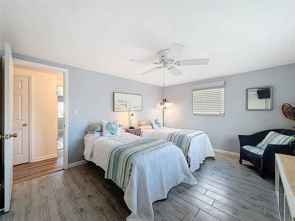 6521 Leeside Isle Hudson, FL 34667 - Photo 19 of 59 a bedroom with two beds and a chandelier