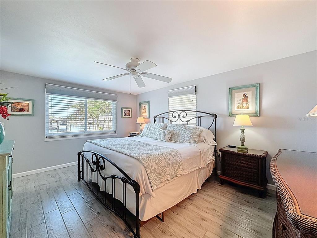 6521 Leeside Isle Hudson, FL 34667 - Photo 24 of 59 a bedroom with a bed a dresser with wooden floor