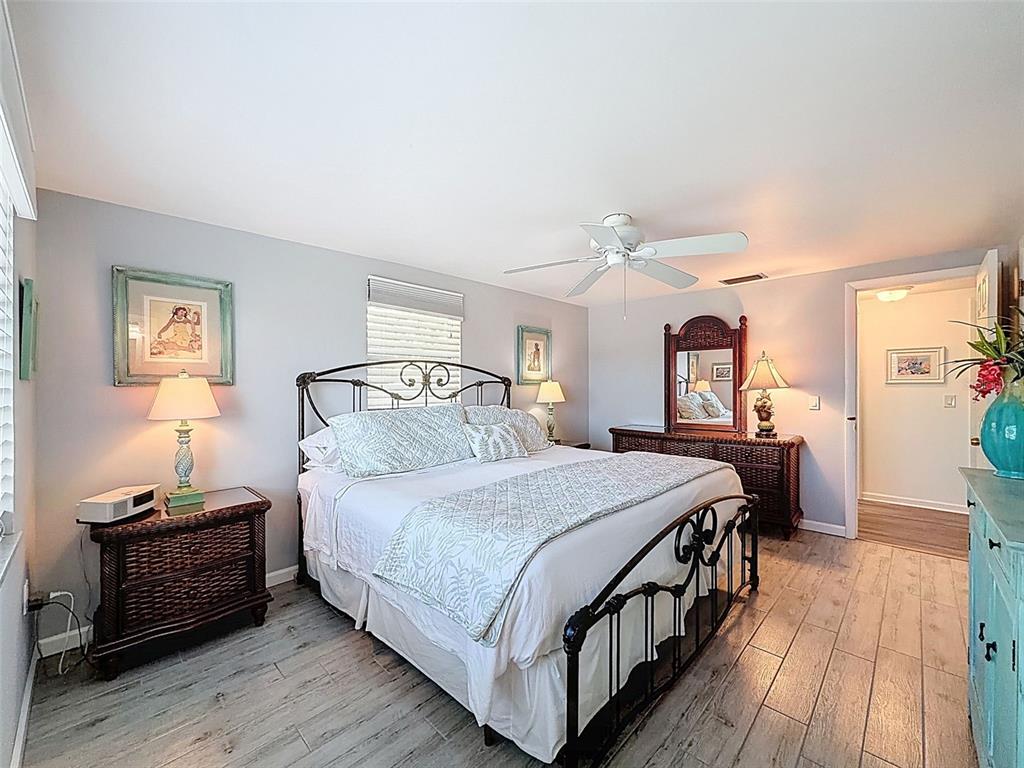 6521 Leeside Isle Hudson, FL 34667 - Photo 25 of 59 a bedroom with a bed and wooden floor