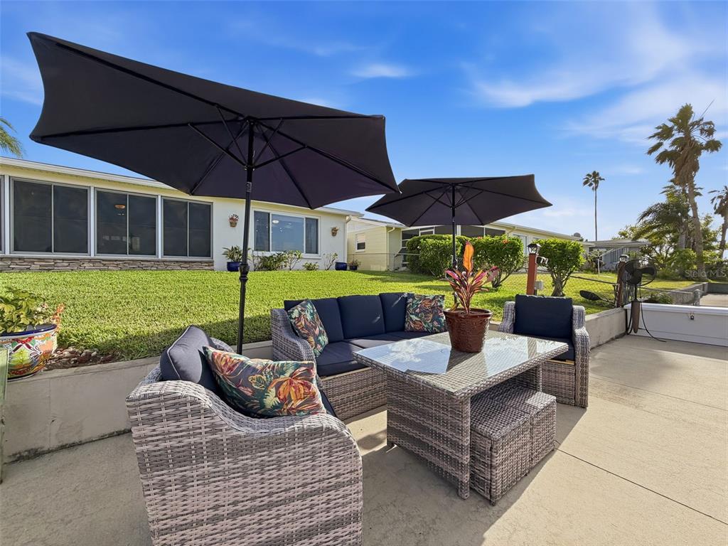 6521 Leeside Isle Hudson, FL 34667 - Photo 37 of 59 a view of a patio with a table and chairs under an umbrella