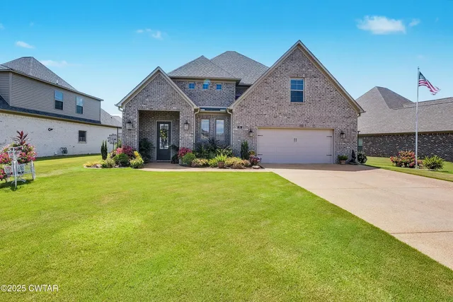 a front view of a house with a yard and garage