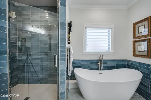 a white bath tub sitting in a bathroom next to a window