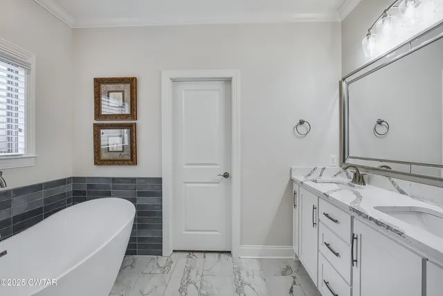 a spacious bathroom with a granite countertop bathtub sink and mirror