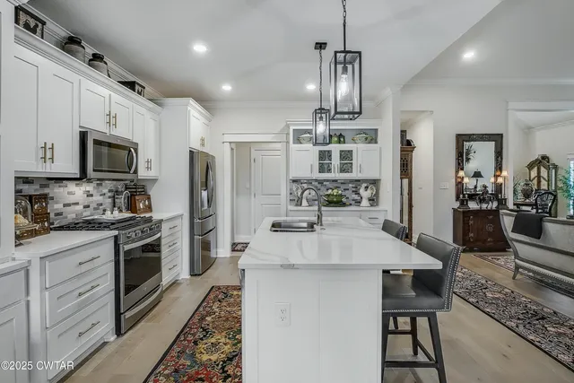 a kitchen with kitchen island granite countertop a center island a sink stainless steel appliances and cabinets