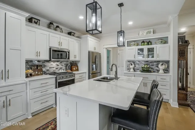 a kitchen with white cabinets and stainless steel appliances