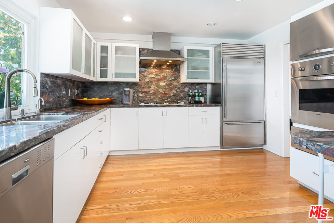 2866 Angelo Drive Los Angeles, CA 90077 - Photo 11 of 31 a kitchen with stainless steel appliances granite countertop a refrigerator and a stove top oven