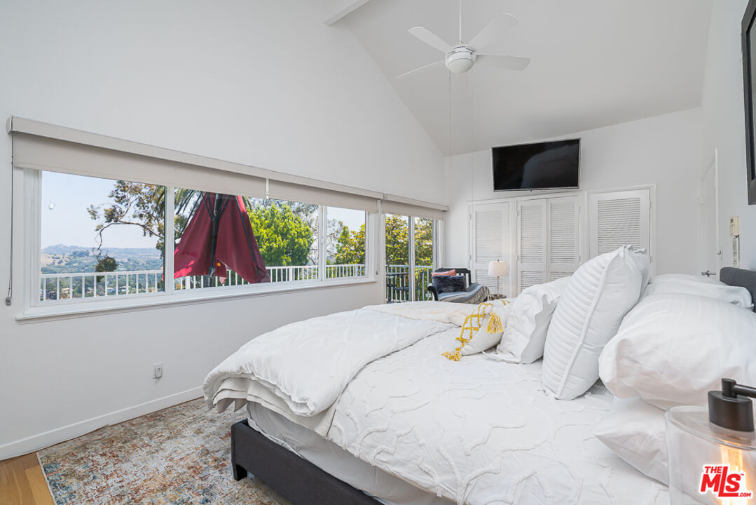 2866 Angelo Drive Los Angeles, CA 90077 - Photo 19 of 31 a bedroom with a bed and a flat screen tv