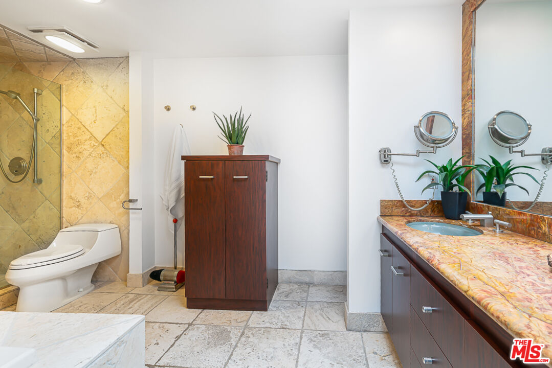 2866 Angelo Drive Los Angeles, CA 90077 - Photo 21 of 31 a bathroom with a granite countertop sink a toilet and shower