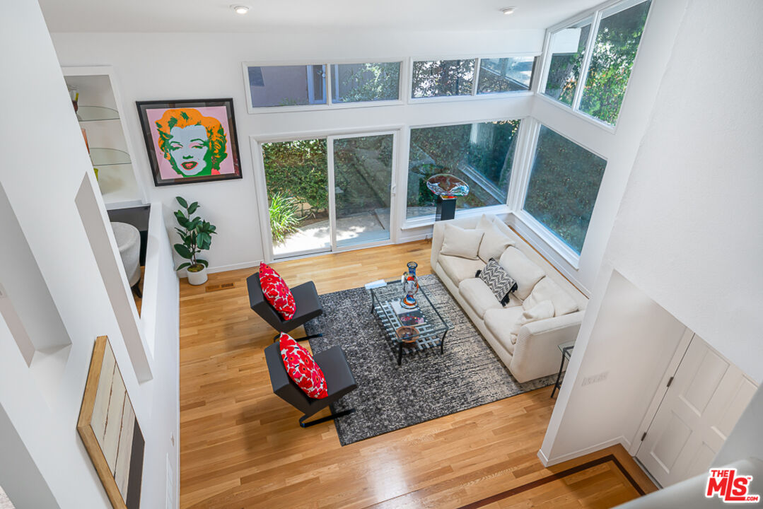 2866 Angelo Drive Los Angeles, CA 90077 - Photo 4 of 31 a living room with furniture floor to ceiling window and floor to ceiling windows
