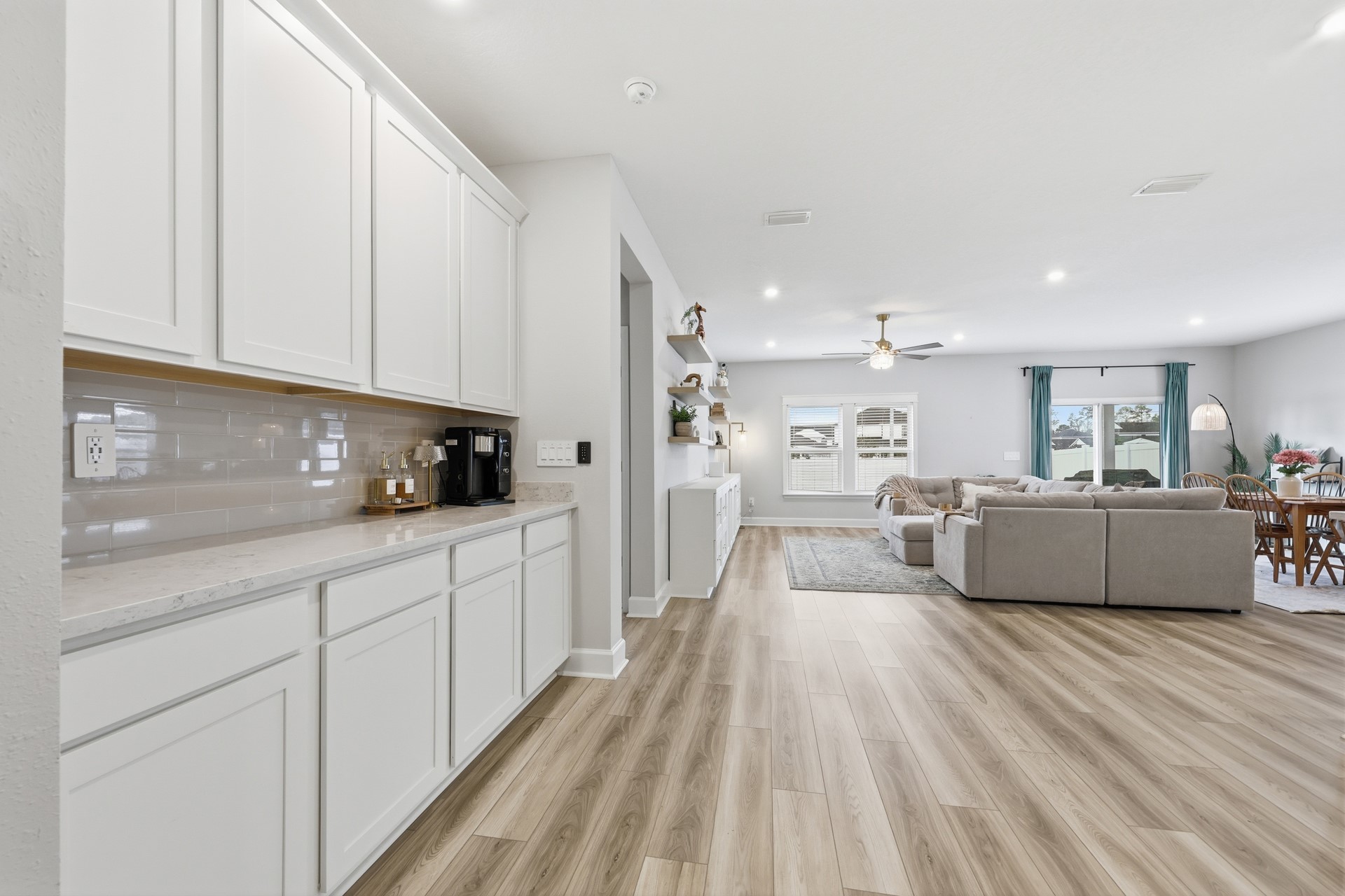 95026 Rocky Place Fernandina Beach, FL 32034 - Photo 9 of 53 a large white kitchen with kitchen island a stove a sink a refrigerator and white cabinets with wooden floor