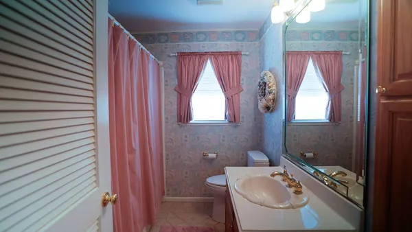 a bathroom with a toilet a sink and mirror