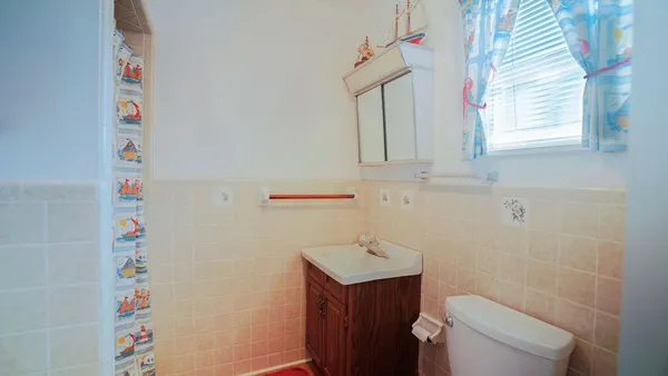 a bathroom with a sink a toilet and window